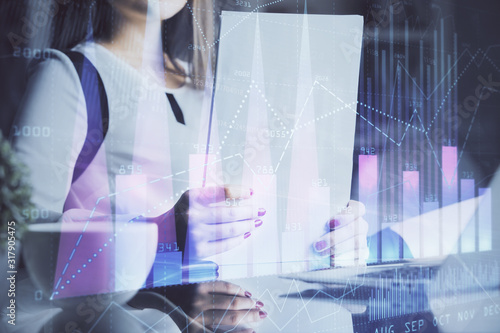 Double exposure of hands making notes with forex chart huds. Stock market concept.