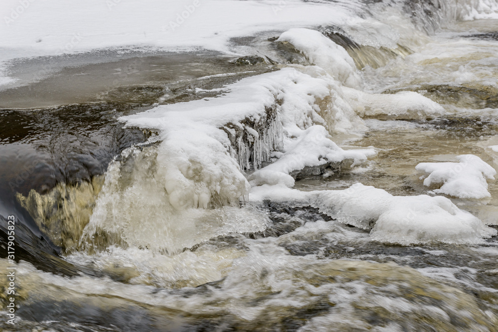 ice and snow on cascades of old broken weir on a river ice and snow on cascades of old broken weir on a river
