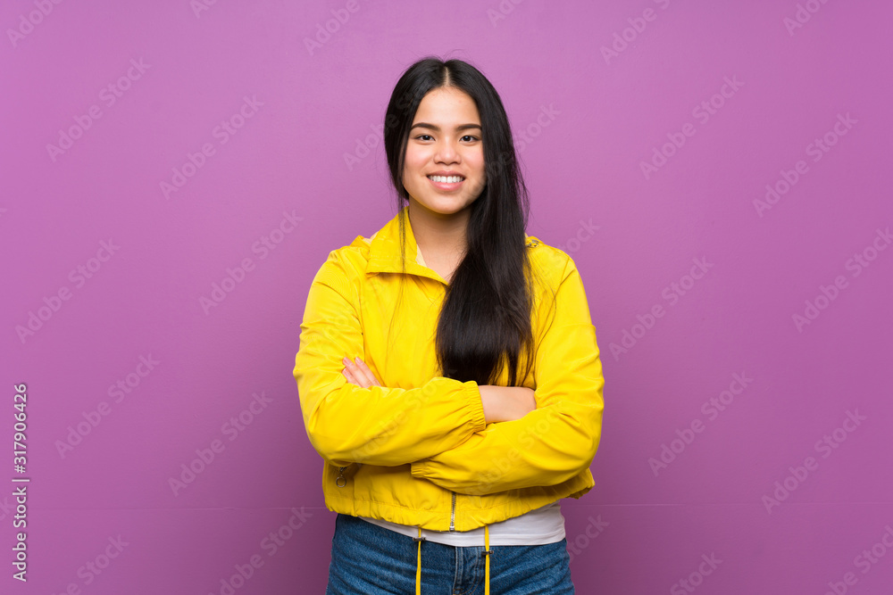 Young teenager Asian girl over isolated purple background keeping the arms crossed in frontal position Young teenager Asian girl over isolated purple background keeping the arms crossed in frontal position