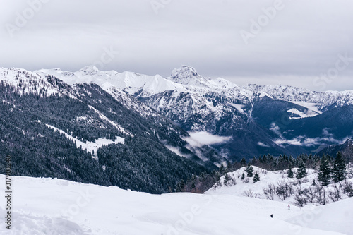 The snowy mountains, the forest and the nature of the Alps during a winter day near the town of Ardesio, Italy - December 2019. © Roberto