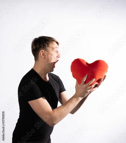 The guy holds in his hands the heart to love Valentines day on white background