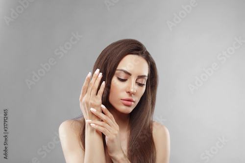 Beautiful model girl with a beige French manicure nail . Fashion makeup and care for hands and nails and cosmetics