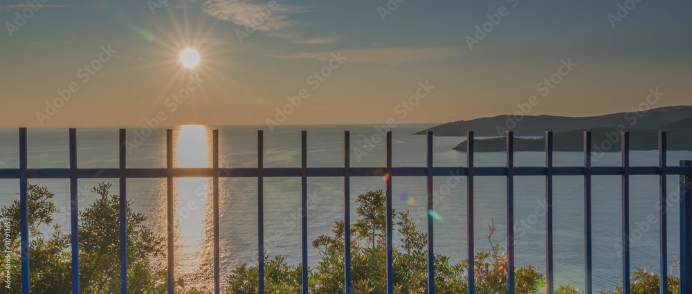 Golden sunrise sunset over the Adratic sea in Montenegro, view from the top of the Mogren Fortress in Budva.Quiet place. Relaxing scene.Calm sea water. Beautiful colors in the sky.
