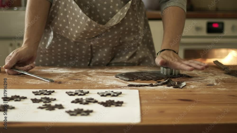 Cutting out gingerbread cookies from dough in kitchen, medium Cutting out gingerbread cookies from dough in kitchen, medium