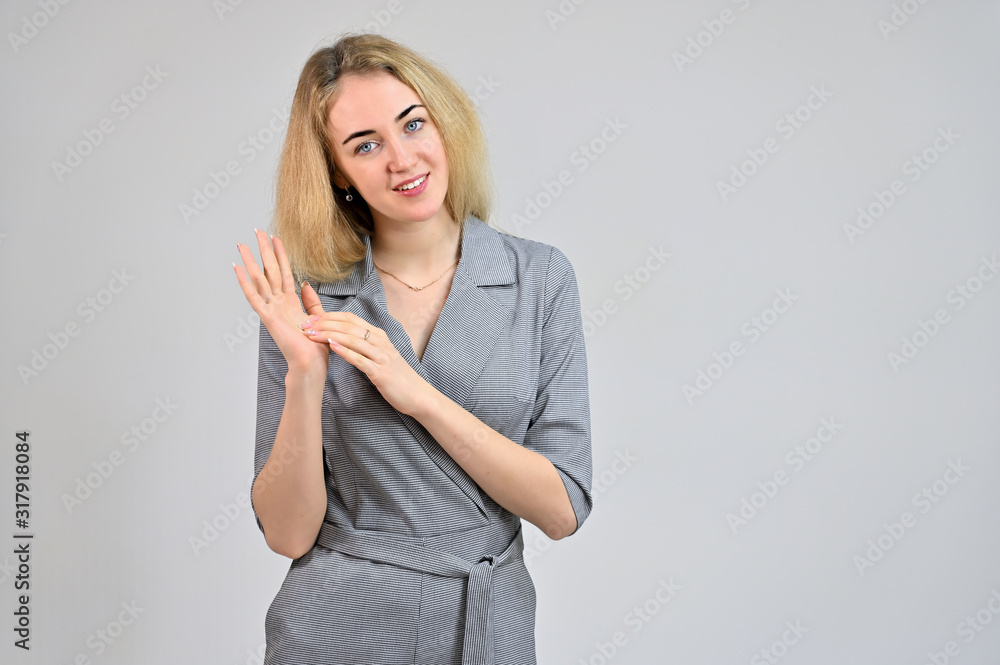 Portrait of a pretty cute smiling young blonde business woman with minimal makeup in a gray suit on a white background. Model Standing directly in front of the camera in various poses. Portrait of a pretty cute smiling young blonde business woman with minimal makeup in a gray suit on a white background. Model Standing directly in front of the camera in various poses.