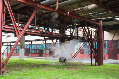 Large iron metal pipeline racks with pipes and drains for the release of supercooled steam at an oil refining petrochemical chemical industrial plant photo