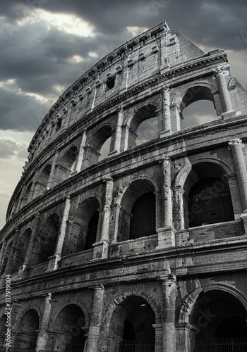 Black and White Colosseum in Rome whit dramatic cloud sky in the background.