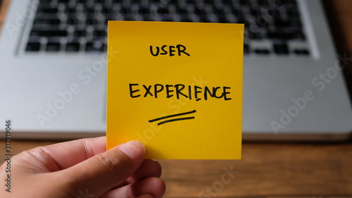 User Experience message concept written post it on laptop keyboard