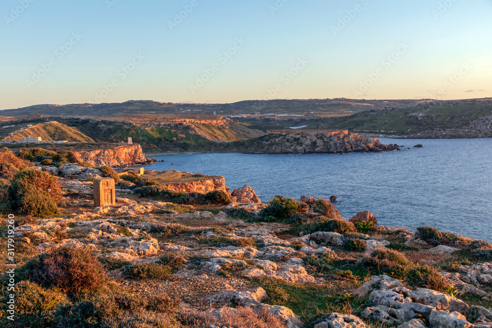 Sunset golden light on the coastline cliffs of the Golden Bay, Mediterranean sea island of Malta