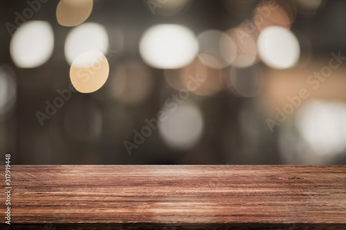 Empty wood table top with lights bokeh and blur restaurant background on vintage tone