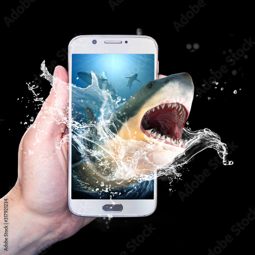 Foto Hand holding a smartphone with a shark coming out of it