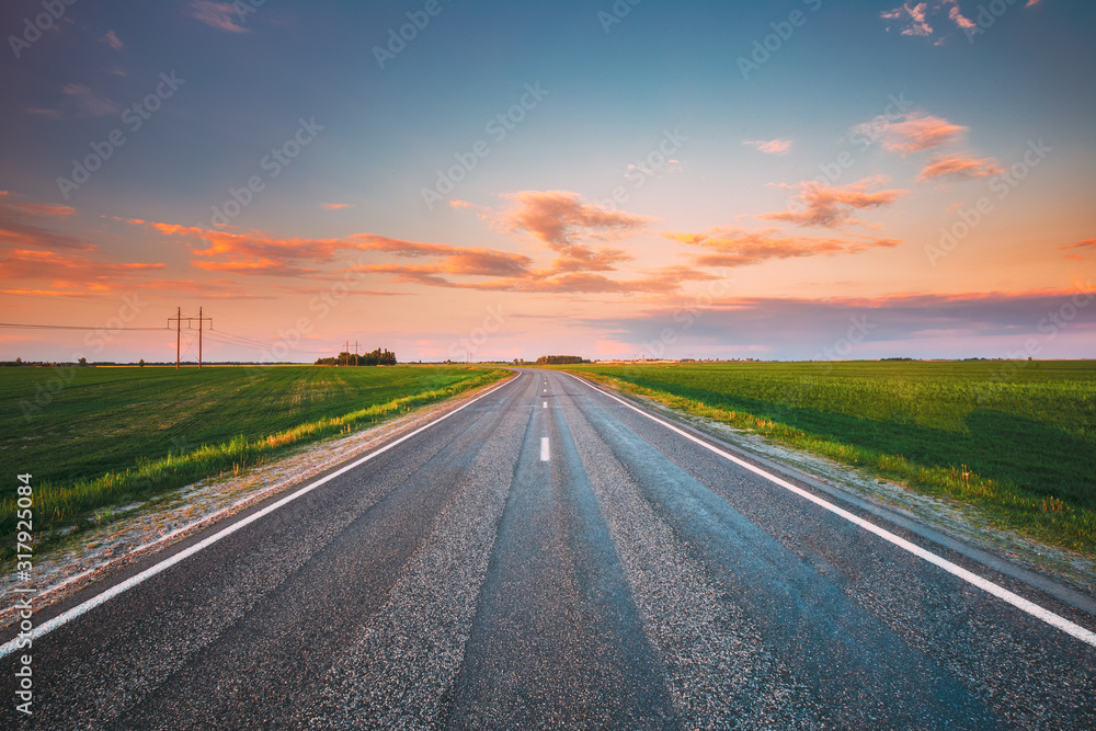 Asphalt Country Open Road Through Spring Fields And Meadows In Sunny Evening. Landscape In Early Summer Season At Sunny Sunset