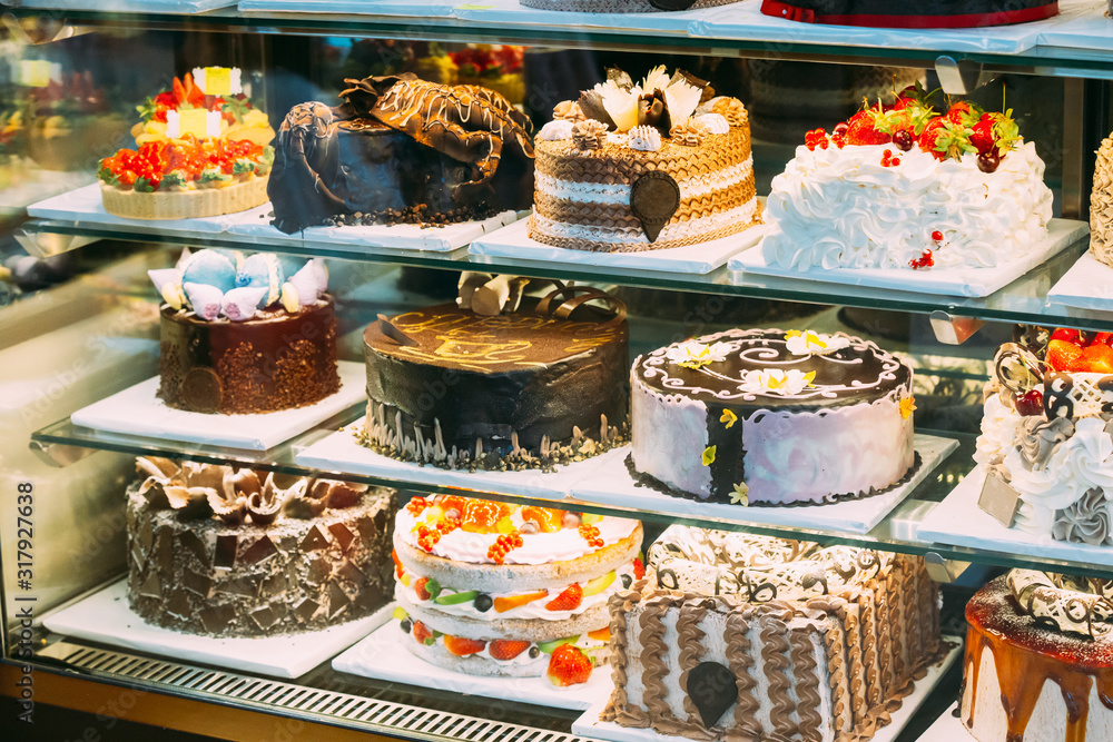 Various Different Types Of Sweet Cakes In Pastry Shop Glass Display. Good Assortment Of Confectionery