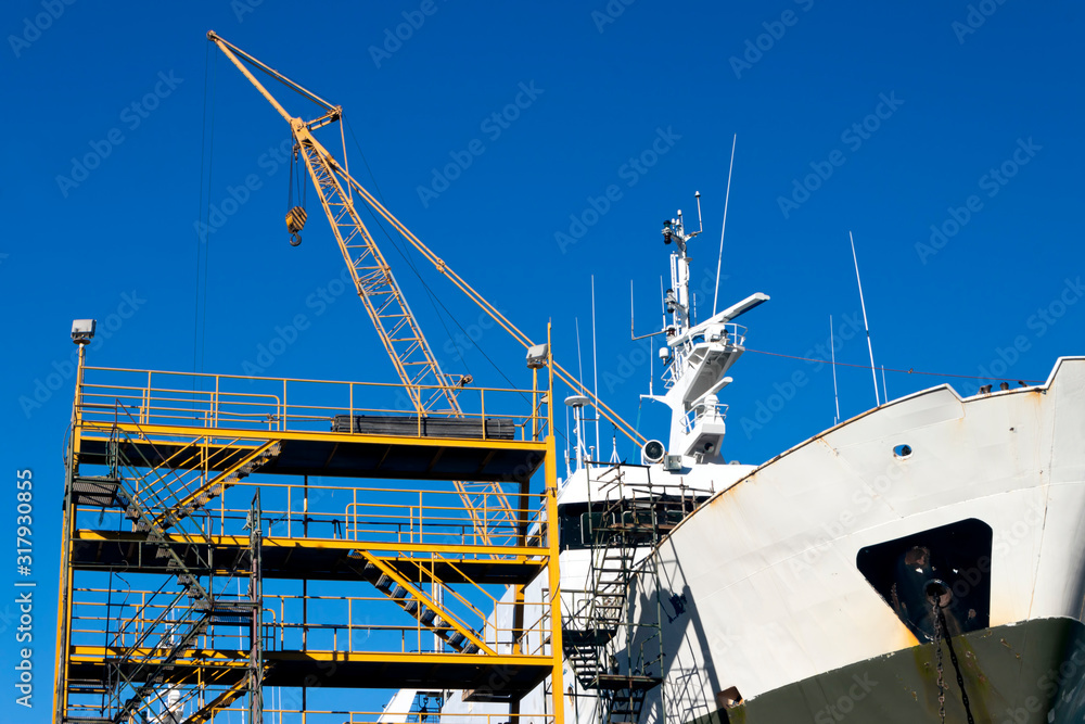 Ship in the shipyard for maintenance and repairs with scaffolds and crane