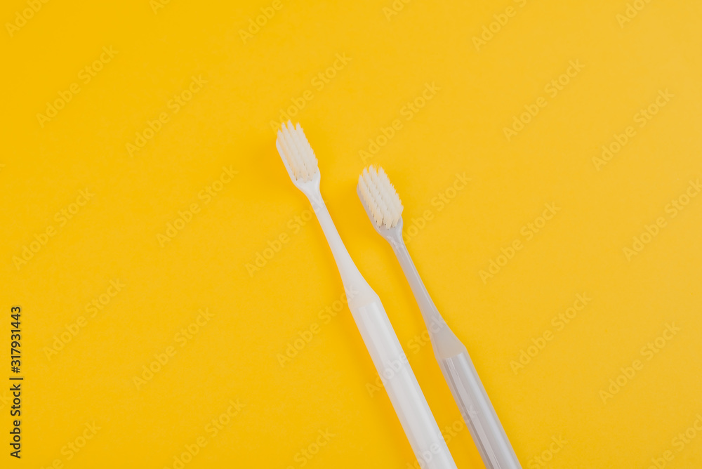 two toothbrushes on a yellow background two toothbrushes on a yellow background