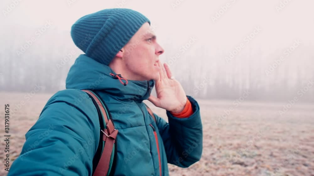 A man in winter clothes is looking for a lost dog. A man in winter clothes is looking for a lost dog.