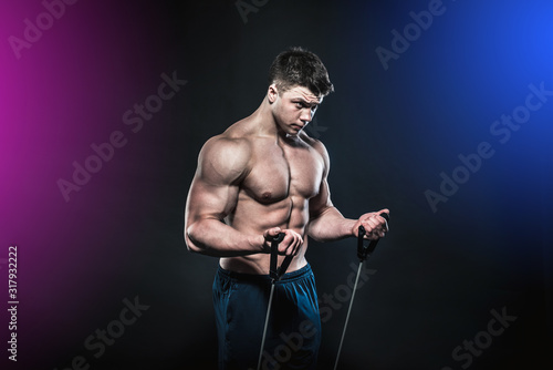 The athlete performs biceps exercises with the help of an expander photo