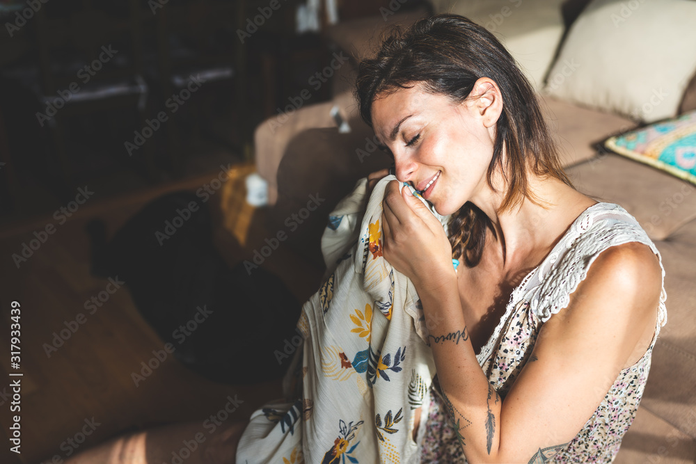 Beautiful Woman Smelling her Clothe at Home. Beautiful Woman Smelling her Clothe at Home.
