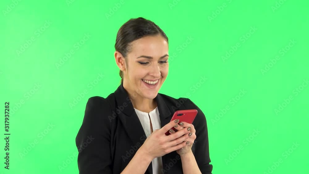 Young smiling woman texting on her phone and rejoice. Green screen Young smiling woman texting on her phone and rejoice. Green screen
