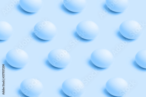 Pattern of eggs on blue color background, minimal food concept and Easter concept