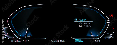 Empty illuminated car dashboard panel concept. Modern fully digital LCD instrument cluster without gauge needles and digits. Close up of two blank speedometer and tachometer circle dials at night. photo