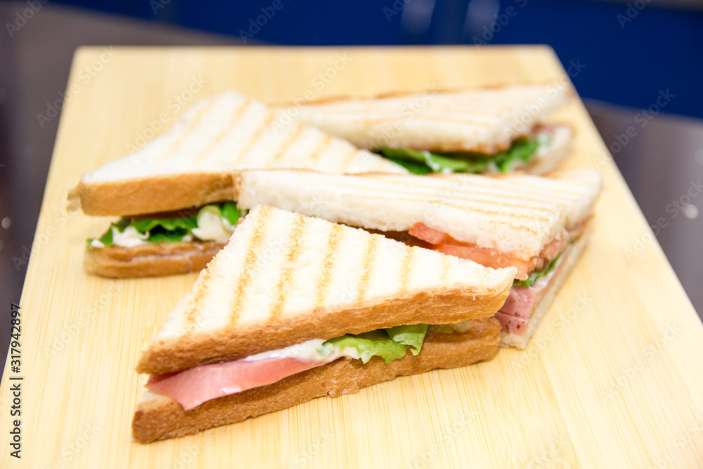 club sandwiches served on a wooden chopping board club sandwiches served on a wooden chopping board