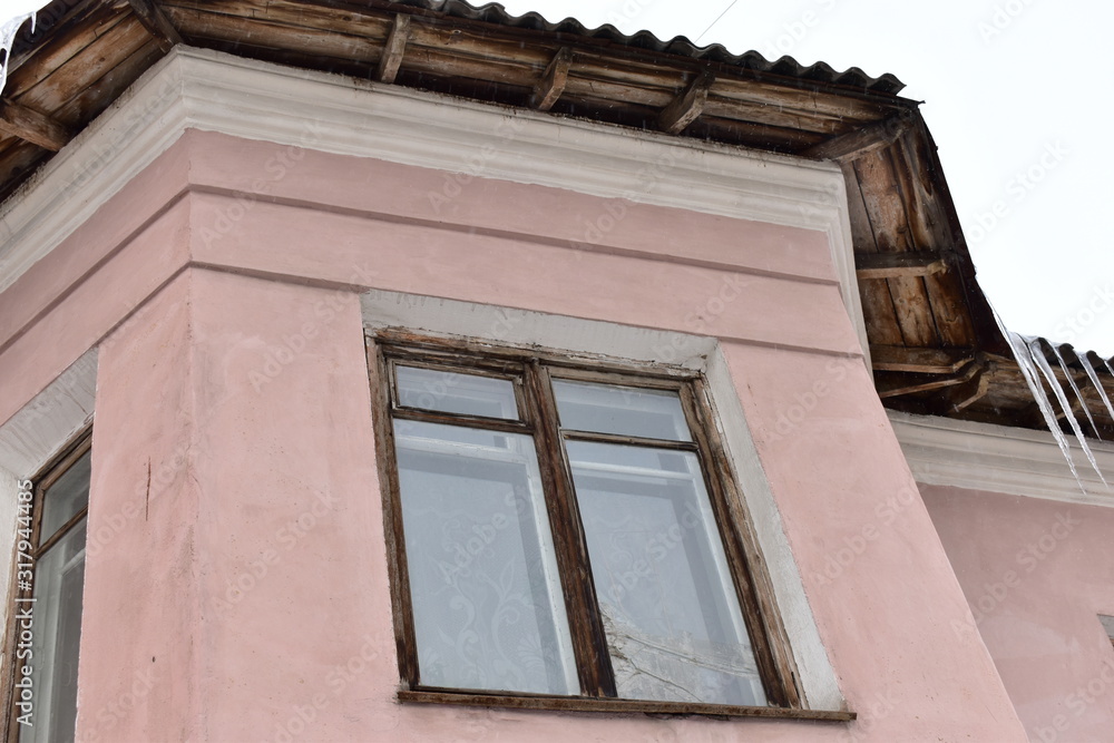 An old pink building with Windows.