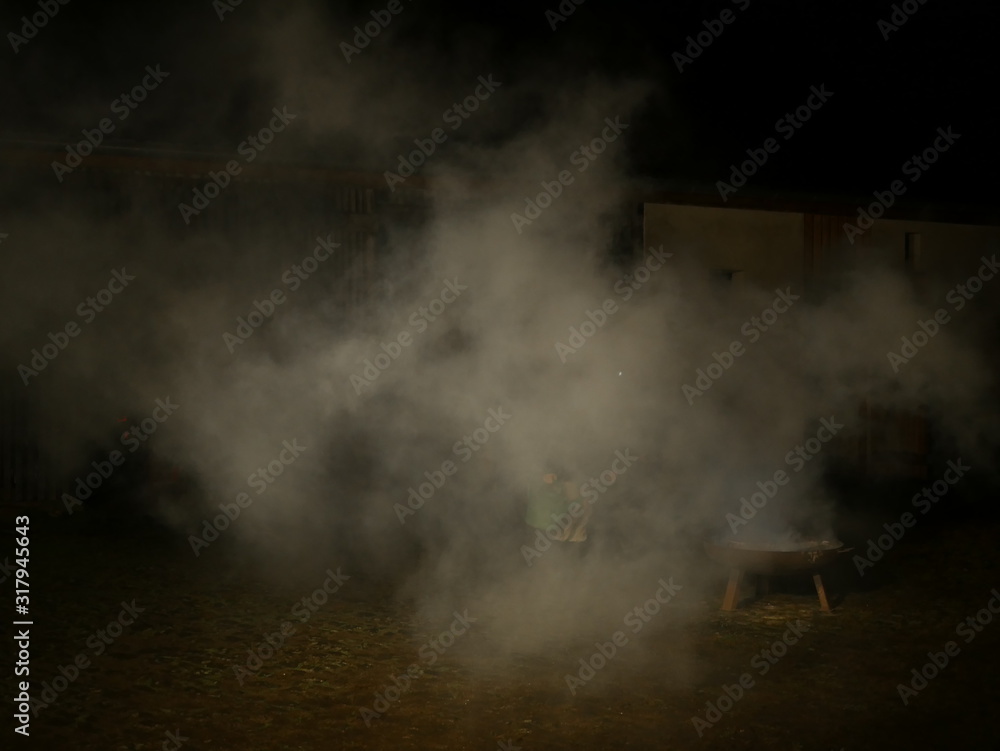 Wasserdampf beim Abloeschen eines Lagerfeuers in einer grossen Feuerschale