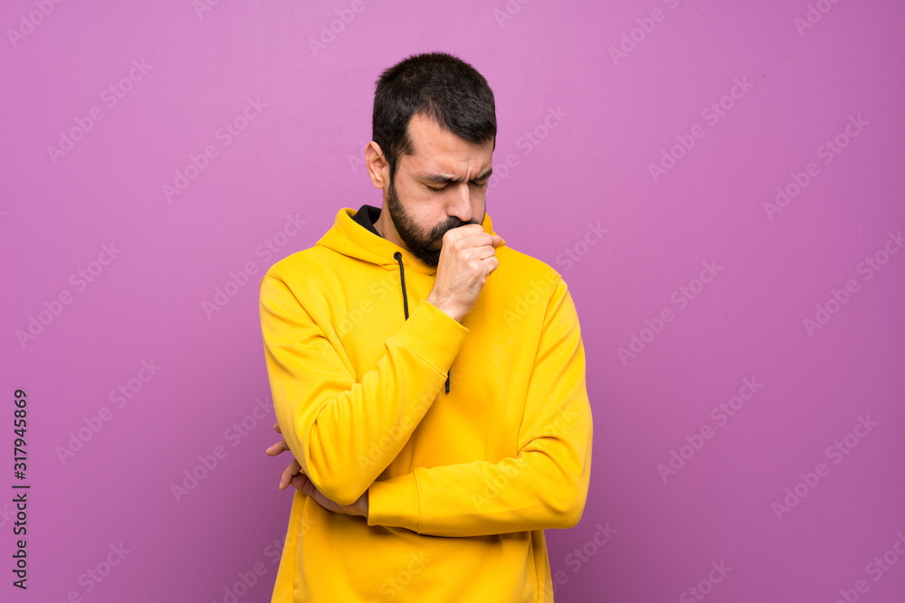 Handsome man with yellow sweatshirt is suffering with cough and feeling bad Handsome man with yellow sweatshirt is suffering with cough and feeling bad