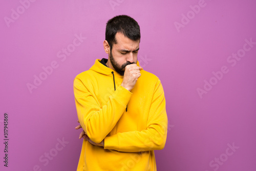 Handsome man with yellow sweatshirt is suffering with cough and feeling bad © luismolinero