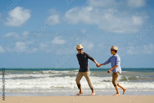 Asian senior couple elder retire resting relax walking at sunrise beach honeymoon.Happy family together people lifestyle