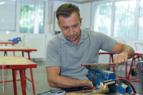 man sanding a metal obeject photo