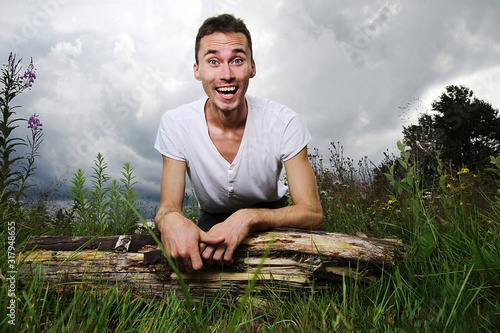 Happy young man on green forest meadow