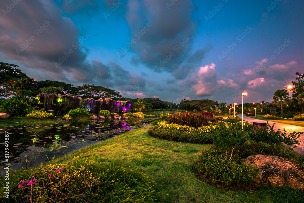 Fototapeta premium Abstract wallpapers of a blurry nature of colorful sky by the lake, with coconut palms and green fields, with cows walking on grass, seen in rural areas