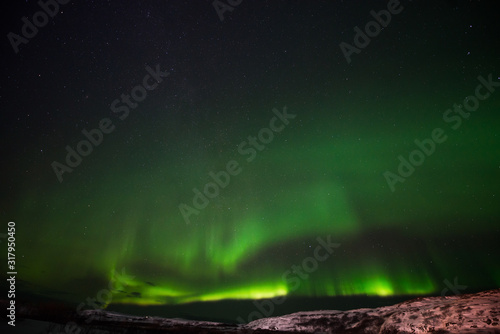 hills  clear starry sky and colorful Northern lights  an incredible natural phenomenon