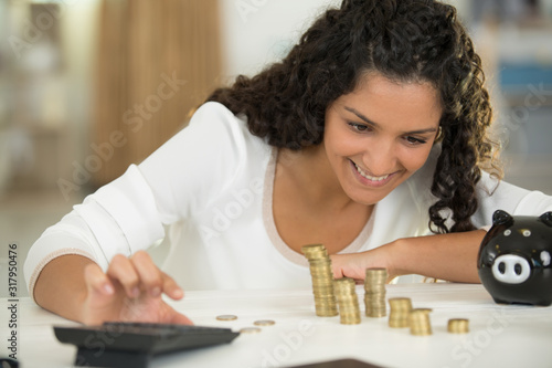 woman with coins and piggy bank at table