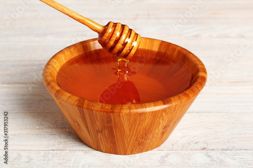 Honey with Honey Dipper in Wooden Bowl photo