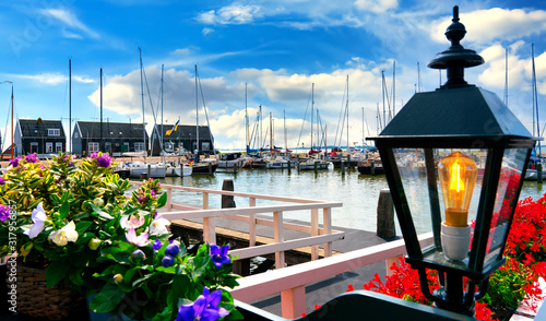 The harbor of Marken with flowers and lamp in foreground. Marken is a small historical dutch village in Netherlands photo