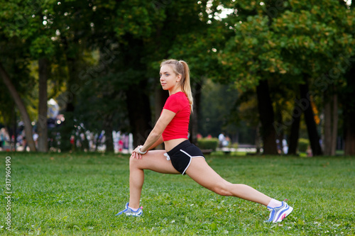 Girl doing lunges. Young slim woman doing lunges in a city park. Outdoors Sports. Healthy lifestyle concept. Morning exercises