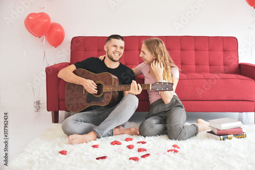 Boy girl playing guitar in room romantic happiness in love Valentine's day