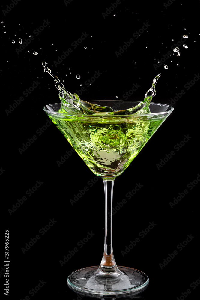martini glass and splash from falling ice on a black background martini glass and splash from falling ice on a black background