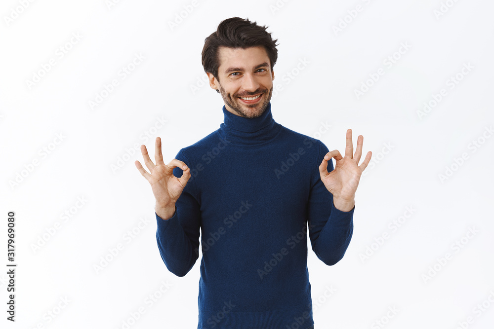 Relaxed and assured, assertive handsome bearded guy in blue high neck sweater, say everything alright, showing okay, acceptance or agree gesture, smiling nod in approval, happy with good result Relaxed and assured, assertive handsome bearded guy in blue high neck sweater, say everything alright, showing okay, acceptance or agree gesture, smiling nod in approval, happy with good result