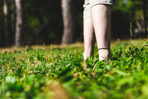 Close-up shot of feet walking in the grass