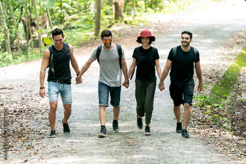Fototapeta Naklejka Na Ścianę i Meble -  Group Of Friends hiking together through the forest