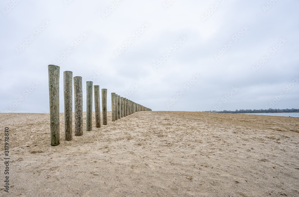Pole heads of wave breakers on the beach