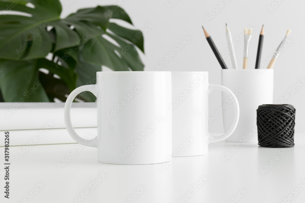 Mug mockup with workspace accessories and a monstera plant. Mug mockup with workspace accessories and a monstera plant.