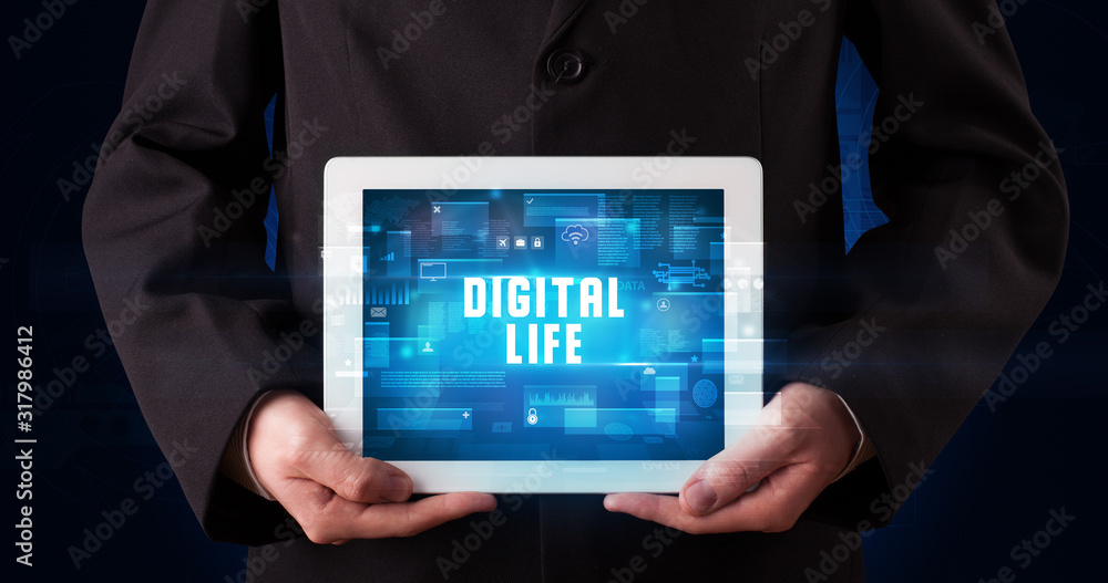 Young business person working on tablet and shows the digital sign: DIGITAL LIFE Young business person working on tablet and shows the digital sign: DIGITAL LIFE