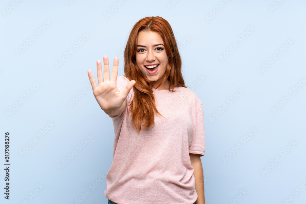 Obraz premium Teenager redhead girl over isolated blue background counting five with fingers