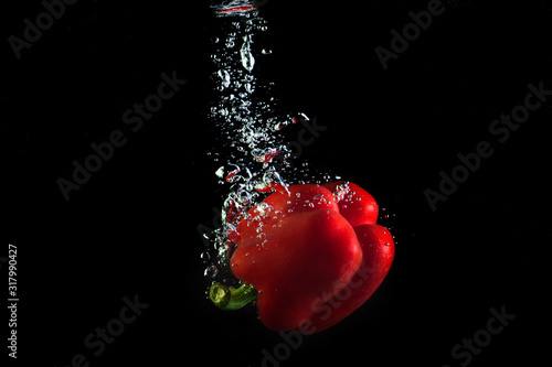 ripe pepper in water. Red and yellow vegetable splash water.