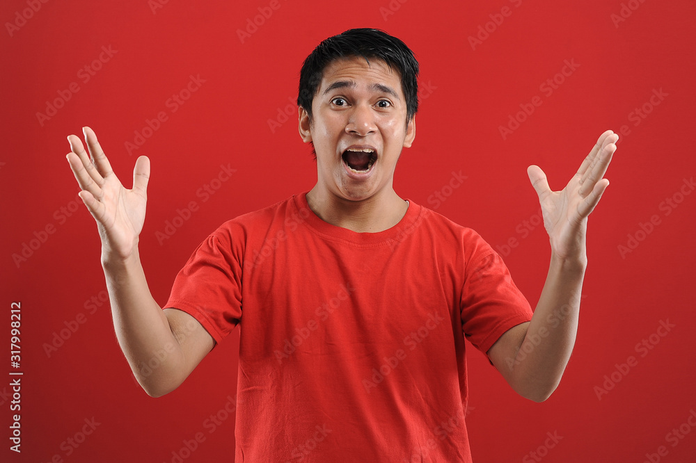 Fototapeta premium Young asian man happy and excited expressing winning gesture. Successful and celebrating